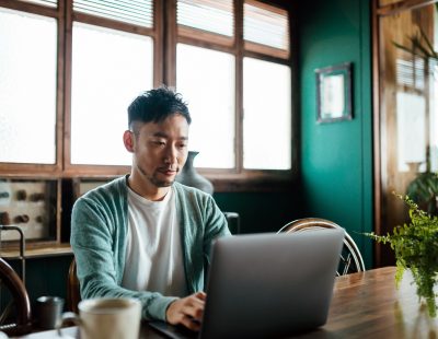 Professional young Asian man working from home, using laptop computer in home office. Remote working, freelancer, small business concept