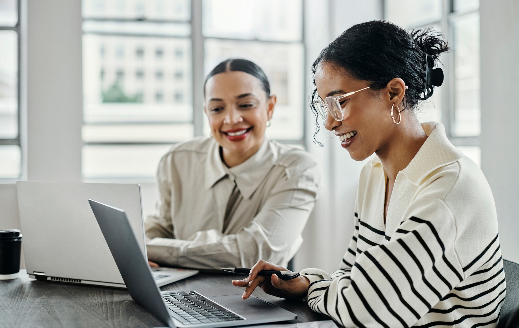 Business women, laptop and and happy team in office for web design, collaboration and training. Planning, digital marketing and coaching by woman leader menor help, explain and support creative goal