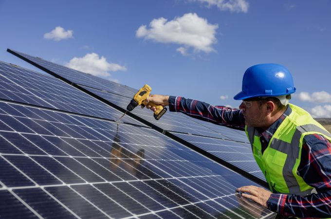 Solar, energy and electricity with a man engineer on a farm to install a panel for alternative power generation. Sustainability, agriculture and carbon footprint with a male technician outdoor.