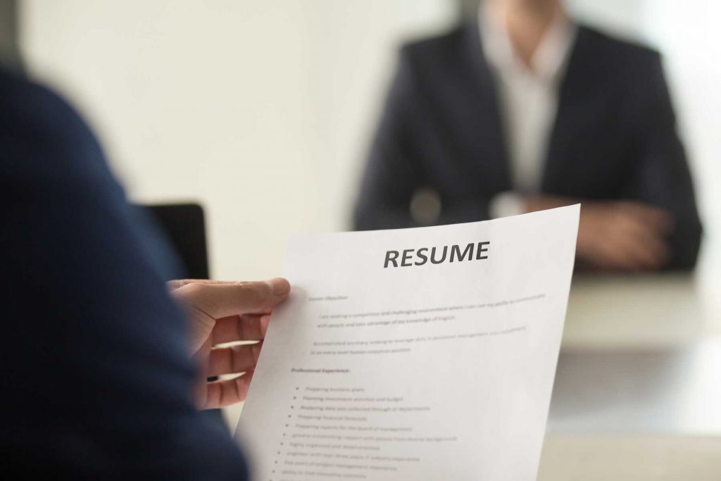 An image of a hand holding a resume.