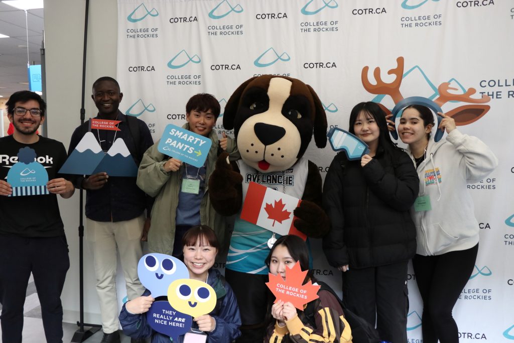 Group of happy international student with COTR mascot.