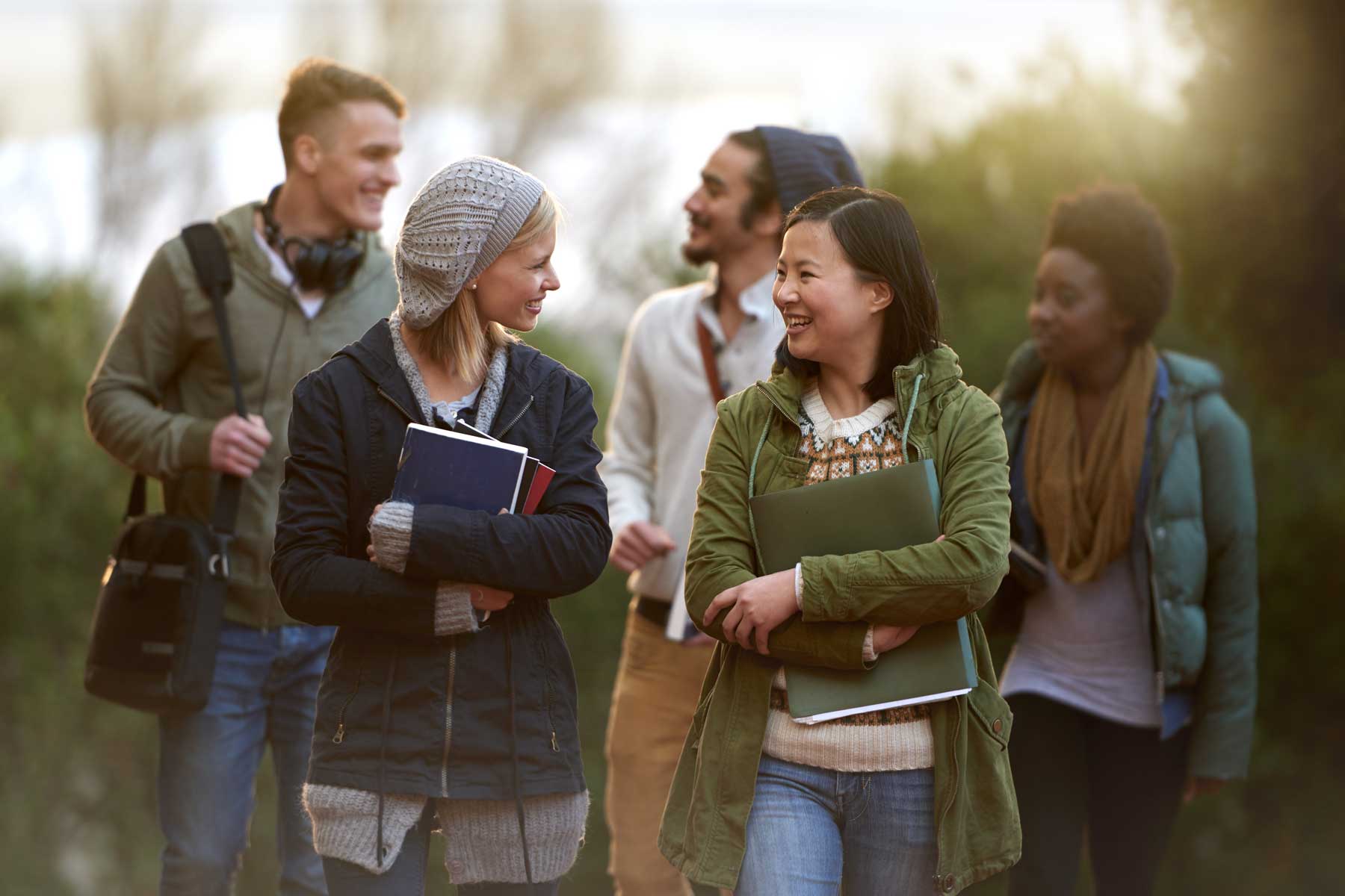 An image of five students walking together in a group outdoors.