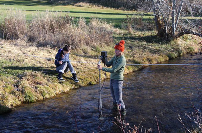 Image shows students doing field work in Joseph Creek in Cranbrook, BC.