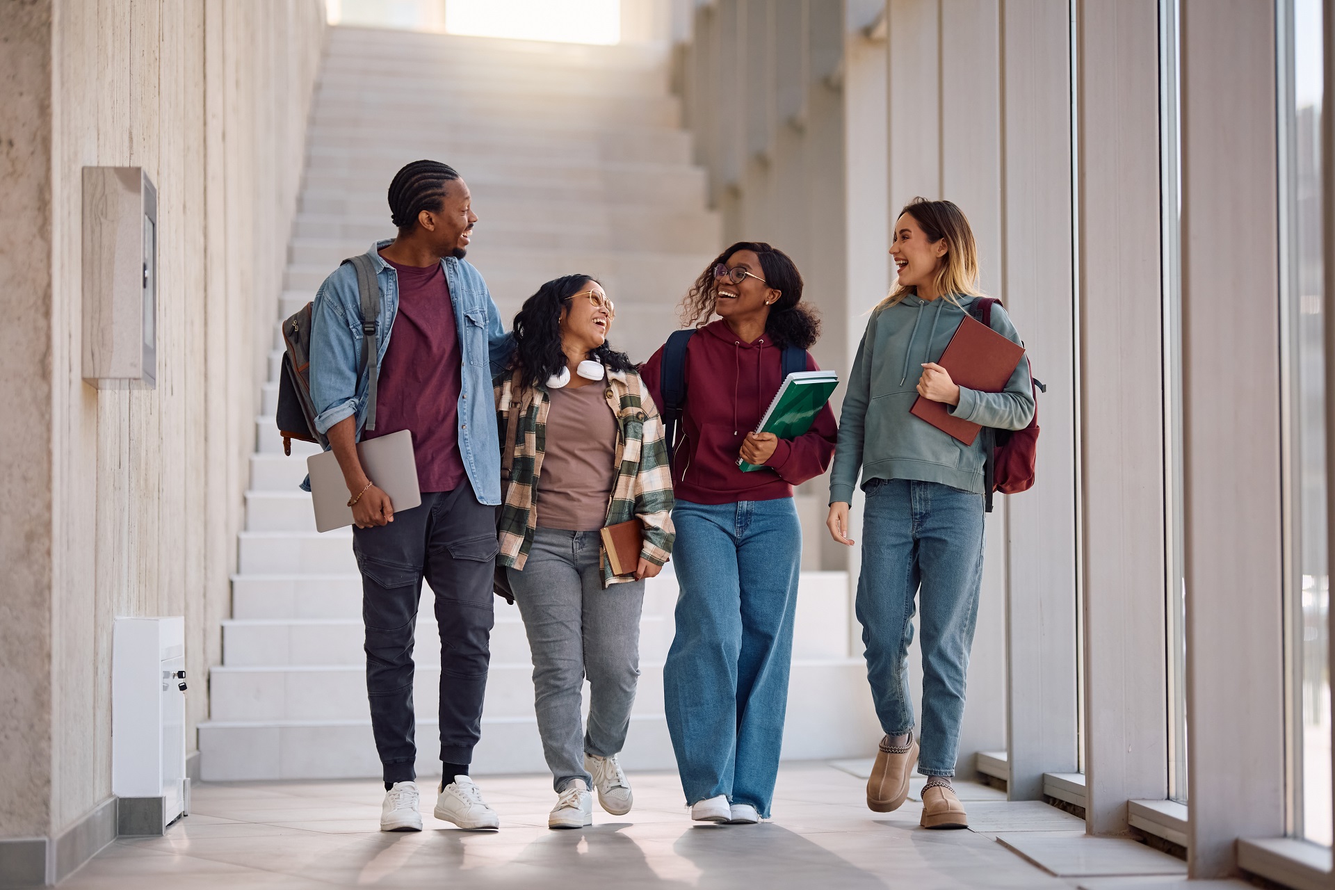 Group of happy college friends having fun and talking while going on a lecture.